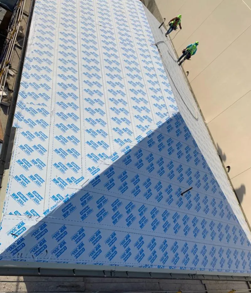 Professional roofers installing underlayment on a metal roof in Hopewell